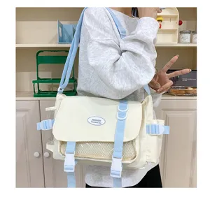 Details of the casual canvas messenger bag with transparent front pocket and blue straps.