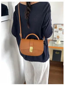 Vista dettagliata della elegante borsa a tracolla marrone con serratura per ufficio.