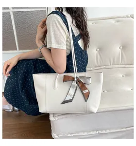 Dettaglio di una elegante borsa tote bianca con fiocco chic, design retrò raffinato.