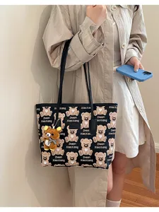 Vue détaillée d'un sac cabas à imprimé d'ours mignon avec un accessoire pendentif charmant.
