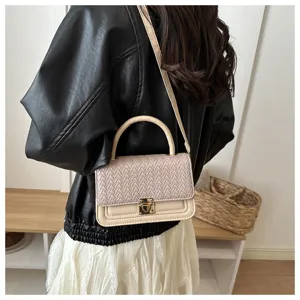Detailansicht der stilvollen gewebten kleinen Schultertasche mit Struktur, getragen vom Model.