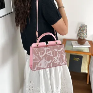 Pink leather top handle shoulder bag with metal V clasp, stylish women crossbody bag.