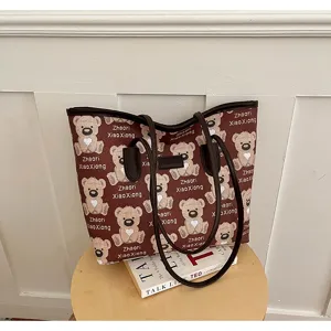 Vue détaillée de ce sac cabas en toile avec motif d'ours marron et poignées en cuir.