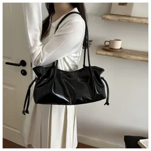Detailed shot of a stylish black glossy faux leather hobo shoulder bag with chic drawstring.