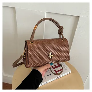 Chic brown woven handbag featuring structured design, elegant top handle and metal turn-lock closure.