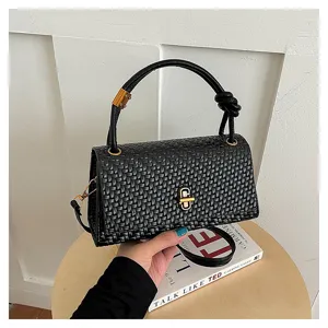 Close-up detail view of black woven texture leather handbag featuring stylish metal clasp.