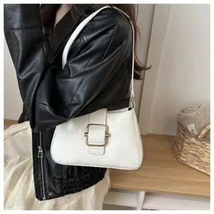 Primo piano dettagliato di borsa a spalla bianca elegante con fibbia dorata chic.