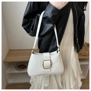 Vista dettagliata di un'elegante borsa a tracolla bianca con fibbia in metallo dorato chic.
