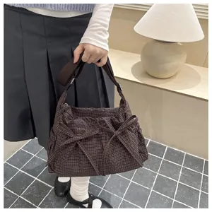 Vista dettagliata della borsa a tracolla a quadri marroni con fiocco stile casual.