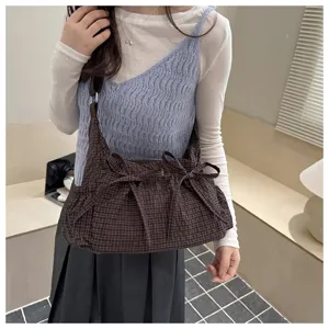 Dettaglio della borsa a tracolla a quadri in stile coreano con graziosi fiocchi laterali.