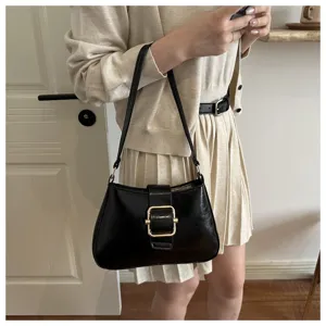 Vista dettagliata di una borsa a spalla nera chic con fibbia dorata per look quotidiano.