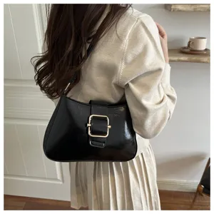Borsa a spalla retrò nera con fibbia metallica chic, perfetta per outfit di moda quotidiani.