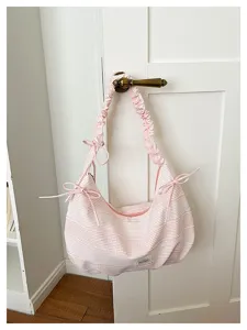 Detailed view of the pink and white striped canvas hobo shoulder bag with cute bow accents.
