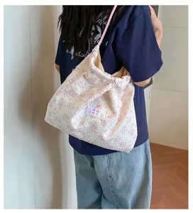 Detail view of the floral crinkled shoulder bag with pink strap and cute patch in use.
