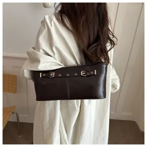 Detail view of stylish dark brown shoulder underarm bag with buckle strap, fashion daily wear.