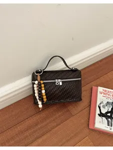 Woven box shoulder bag with top handle and beaded pendant for women daily commuting style details.