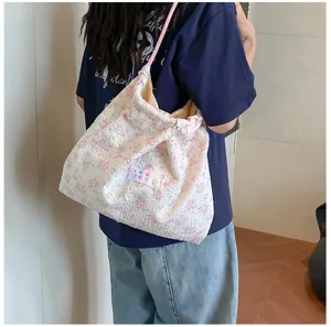Detail view of the floral seersucker shoulder bag showing textured fabric and drawstring.