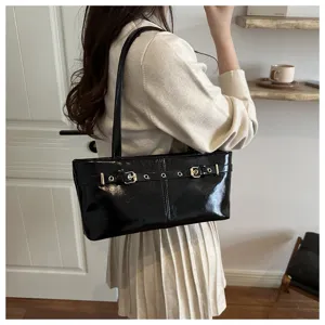Black patent leather shoulder bag for women, stylish underarm bag with metal buckle strap.