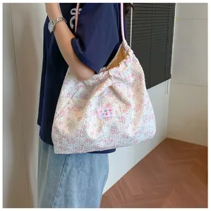 Floral puckered fabric shoulder bag detail shot showing texture and pink drawstring strap.