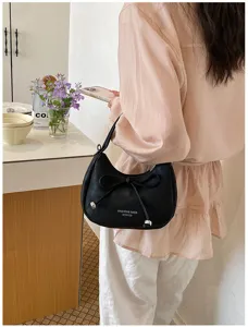 Detailansicht einer stilvollen schwarzen Schultertasche mit Schleife für den Alltag.