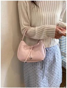 Rosa Hobo Umhängetasche für Damen, modische Beuteltasche mit Schleife und Kordelzug Detail.