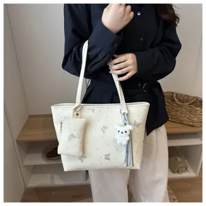 Vista di dettaglio della borsa tote elegante con un ciondolo carino e stampa farfalla.