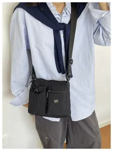 Black nylon crossbody bag with multiple pockets for daily commuting and outdoor casual use.
