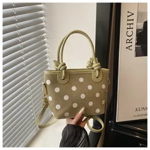 Sac seau à pois vert tendance pour femme, avec poignées chic et bandoulière réglable.