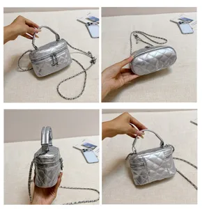 Vue de détail du mini sac boîte matelassé métallique argenté, montrant la texture et la chaîne.