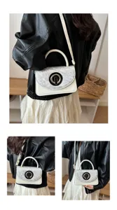 Vista detallada del elegante bolso blanco de hombro con solapa gris y cierre dorado elegante.