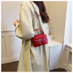Vue détaillée du mini sac boîte matelassé chic avec chaîne porté sur un élégant trench.