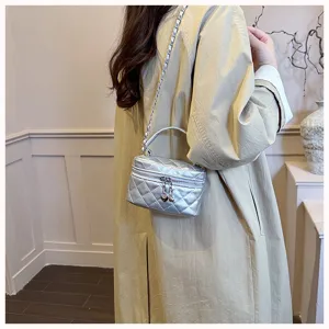Détail du mini sac matelassé argenté avec bandoulière chaîne chic et élégante finition métallique.