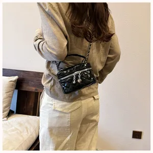 Gros plan détaillé du mini sac vanity noir matelassé doté d'une élégante bandoulière.