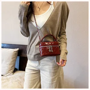 Vue détaillée d'un mini sac à bandoulière matelassé chic avec chaîne et poignée pour femmes.