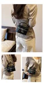 Mini sac boîte en cuir verni matelassé noir, bandoulière chaîne classique, vue détaillée.