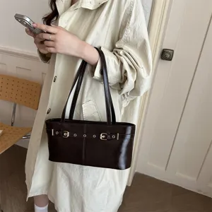 Women's brown shoulder handbag, minimalist style baguette bag with metal buckle and strap design.