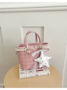 Close-up view of pink plaid handbag showing detailed lace trim and star pendant on round table.