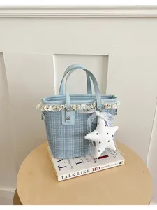 Light blue plaid bucket bag featuring delicate lace trim and a white star pendant detail.