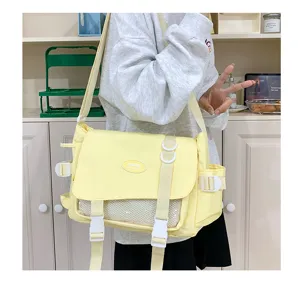 Detailed view of casual yellow messenger bag with clear mesh pocket and adjustable side buckles.