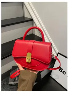 Elegante borsa a tracolla rossa con manico e serratura dorata, accessorio chic da donna.