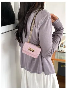 Gedetailleerd overzicht van een chique roze tweed ketting crossbody tas met slot.
