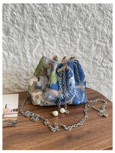 Nahaufnahme der Pailletten bestickten Beutel tasche mit Blumenmuster und Metallkette.
