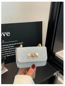 Glitterende strass mini schoudertas met gouden kettingriem en chique draaisluiting.