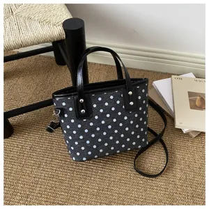 Vintage Polka Dot Mini Eimer Tasche mit schwarzem Lederbesatz und Umhängegurt für Damen.