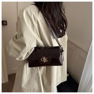 Vue rapprochée du sac à bandoulière marron foncé avec serrure métallique en intérieur.