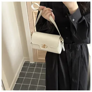 Élégant sac à bandoulière rétro blanc avec fermoir métallique, sac de banlieue chic.