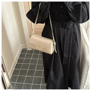 Sac à main bandoulière vintage minimaliste pour femme avec fermoir métallique chic.