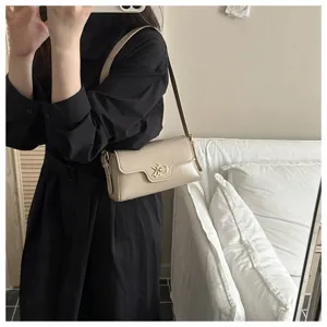 Vue détaillée du sac porté épaule rétro beige avec fermoir métallique unique, style chic.