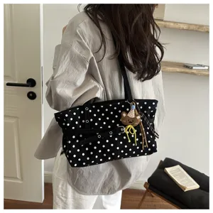 Borsa a tracolla in tela a pois neri e bianchi, elegante accessorio casual per il lavoro.