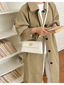 Detail shot of a stylish white quilted shoulder bag with chain strap and elegant gold hardware.